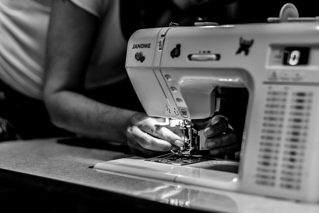 man setting up the needle of the sewing machine