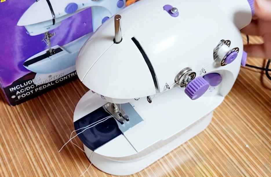 white colored portable sewing machine 